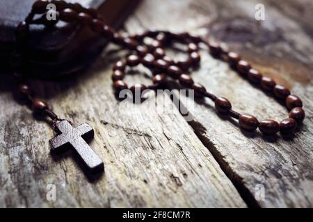 Perle di Rosario e croce crocifisso su sfondo sacro della bibbia Foto Stock