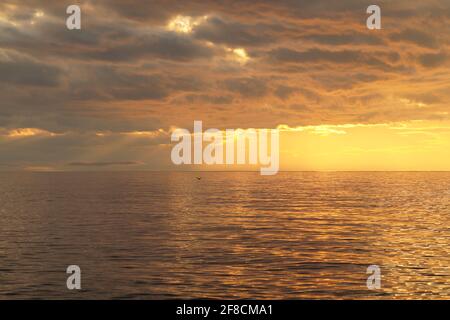 I raggi del sole che tramonta si infrangono attraverso le nuvole Sul lago Bai Foto Stock
