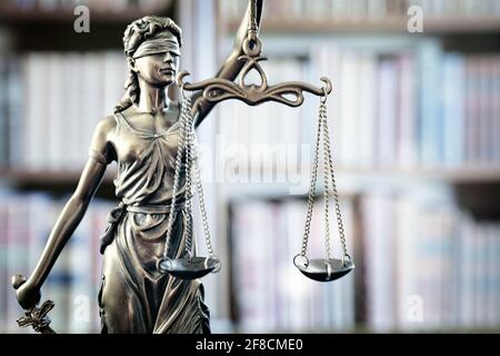 Legge e legale statua di Lady Justice scale di giustizia e libri di legge su libreria Foto Stock