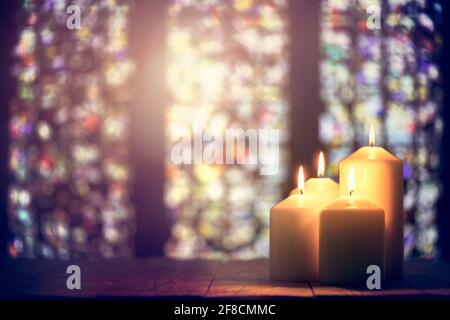 Candele che bruciano in uno sfondo di chiesa Foto Stock