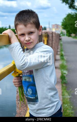 ragazzo in piedi vicino al fiume nel parco Foto Stock