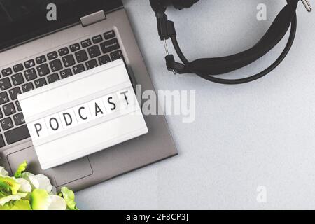 Podcast Concept sfondo, piano e vista dall'alto foto con scatola luminosa e lettere, laptop con cuffie sul tavolo da ufficio Foto Stock