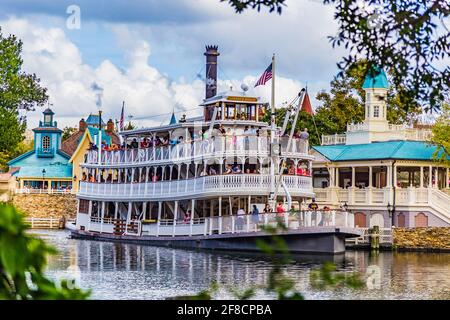 Big Steam Boat in Disney World. La gente sta godendo la corsa fantastica attraverso il fiume all'interno del grande parco. Un sacco di bambini stanno avendo divertimento e i genitori. Foto Stock
