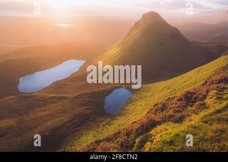 Etereo, suggestivo tramonto d'oro o luce dell'alba sul paesaggio ultraterreno del Cleat al Quiraing sulla cresta trottternish, Isola di SK Foto Stock