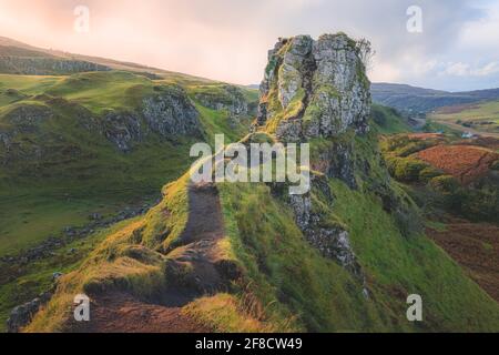 L'attrazione turistica sulla collina Castle Ewan al Fairy Glen in tramonto dorato o all'alba luce sull'Isola di Skye, Scozia. Foto Stock