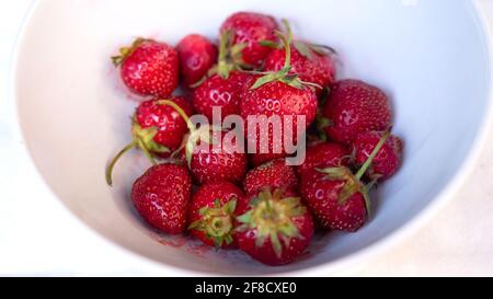 Fragole rosse mature in un recipiente bianco Foto Stock