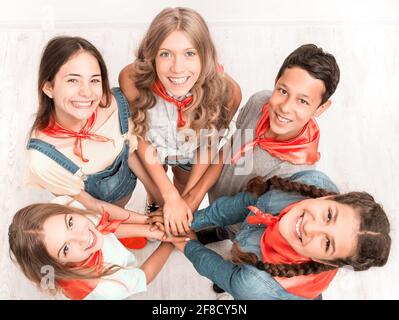 Sorridente carino bambini mantenendo le mani insieme e guardare in su verso la telecamera Foto Stock