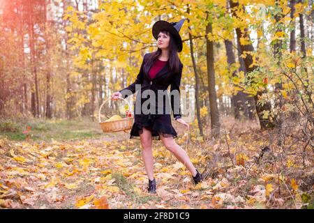 strega nella foresta autunnale. halloween cosplay. halloween festa autunnale. bella donna caucasica in costume di garofano Foto Stock