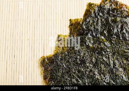 Sushi nori foglie su sfondo di bambù con spazio libero. Vista dall'alto Foto Stock