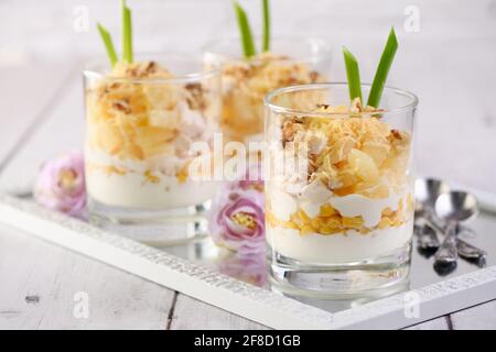 Insalata di pollo con ananas, mais, condita con yogurt greco, noci tritate e formaggio grattugiato. Un'insalata in un bicchiere, un'ottima idea per servire il cibo in p Foto Stock