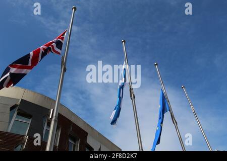 Union Jack Scottish Sessyre e le bandiere dell'Unione europea Flying At Mezzo mast fuori del Parlamento scozzese in lutto per il principe Filippo Foto Stock