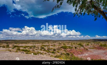 El chocon area desertica paesaggio, preso in una soleggiata mattina calda sotto un cielo blu con alcune nuvole bianche. Foto Stock