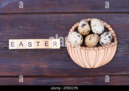 Uova di pasqua di quaglia piatte su legno scuro. Foto Stock