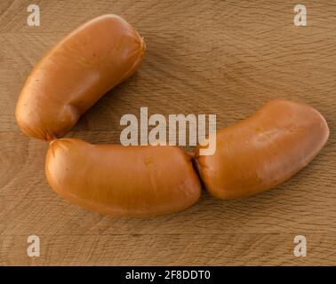 Salsicce bollite, salsicce di carne su tavola di legno Foto Stock