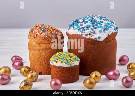 Cupcake pasquali e uova decorative su tavola bianca. Foto Stock