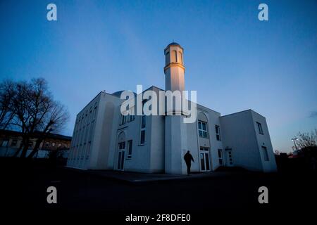 Berlino, Germania. 13 Apr 2021. Un credente arriva alla Moschea Khadija della comunità Ahmadiyya per le preghiere serali all'inizio del mese di digiuno musulmano del Ramadan. Credit: Christoph Soeder/dpa/Alamy Live News Foto Stock