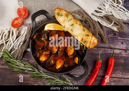 Stufato di cozze tradizionale francese-corsa con cozze in cima in un piastra Foto Stock