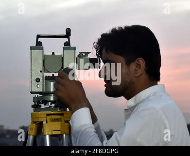 Peshawar. 13 Apr 2021. Un uomo osserva la luna crescente attraverso un telescopio nel Peshawar del Pakistan nord-occidentale il 13 aprile 2021. La luna a mezzaluna del Ramadan è stata avvistata in Pakistan martedì sera e il mese santo inizierà ufficialmente mercoledì, secondo un annuncio ufficiale del comitato di avvistamento della luna del paese. Credit: Saeed Ahmad/Xinhua/Alamy Live News Foto Stock