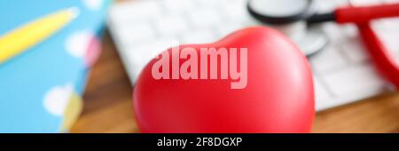 Sul tavolo si trova il cuore rosso stetoscopio e la tastiera. Foto Stock