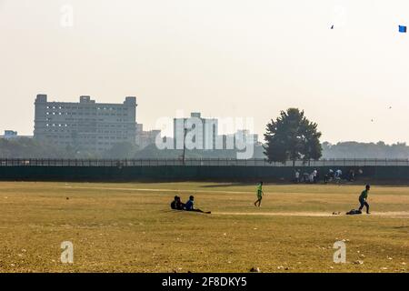 Kolkata, Bengala Occidentale, India - Gennaio 2018: Persone che giocano a cricket sull'erba verde dei vasti spazi aperti dei terreni di Maidan a Kolkata. Foto Stock