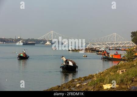 Kolkata, Bengala Occidentale, India - Gennaio 2018: Barche di legno sul fiume Hooghly con una vista dello storico ponte Howrah presso il Prinsep ghat nel ci Foto Stock