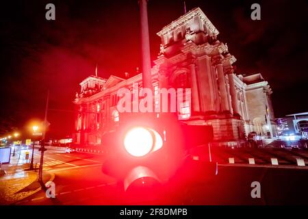 Berlino, Germania. 13 Apr 2021. Di notte, davanti all'edificio del Reichstag, splende un semaforo rosso. Credit: Christoph Soeder/dpa/Alamy Live News Foto Stock