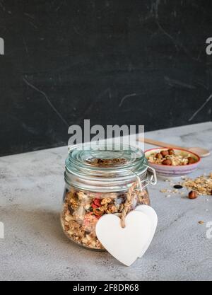 Granola fatta in casa con frutta secca e noci in un vaso mason Foto Stock