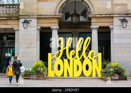 Londra, Regno Unito. 13 aprile 2021. La gente cammina oltre il cartello giallo Hello London a Covent Garden Market. Credito: Waldemar Sikora Foto Stock