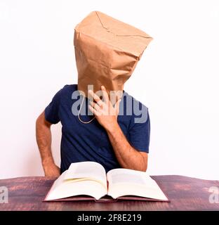 Uomo pensivo anonimo con borsa di carta sulla testa. Foto Stock