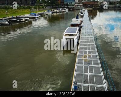 Wroclaw, Polonia - Giugno 16 2020: Guardando giù dal Ponte dell'Università al ponte pedonale sul fiume Odra con poche piccole barche ormeggiate Foto Stock