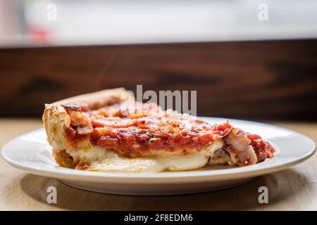 Una deliziosa fetta di pizza Deep Dish famosa in tutto il mondo di Chicago. Foto Stock