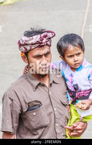 Bali, Indonesia - 6 luglio 2011: Uomo balinese con figlia che va al tempio. La maggior parte dei balinesi segue la religione indù. Foto Stock