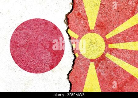 Giappone vs Macedonia bandiere nazionali su pareti di cemento fessurato Foto Stock