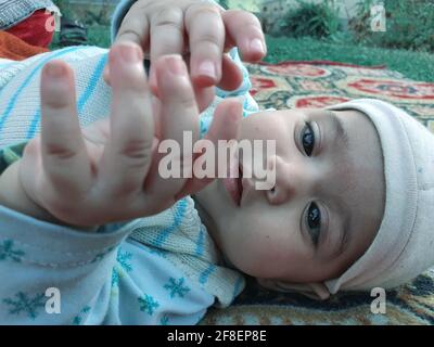 Bella ragazzina pose diverse sembra molto bello. I bambini piccoli dopo il loro nascita hanno guance morbide e un volto innocente con un sorriso sguazzante. Foto Stock