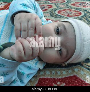 Bella ragazzina pose diverse sembra molto bello. I bambini piccoli dopo il loro nascita hanno guance morbide e un volto innocente con un sorriso sguazzante. Foto Stock