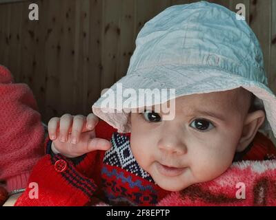 Bella ragazzina pose diverse sembra molto bello. I bambini piccoli dopo il loro nascita hanno guance morbide e un volto innocente con un sorriso sguazzante. Foto Stock