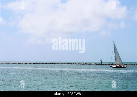 Bellissima barca a vela a vela con bassa marea con passeggeri a bordo navigando attraverso il vento a Miami Beach, Florida vicino al molo di South Pointe. CopySpace Foto Stock