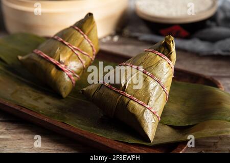 Primo piano di zongzi, uno spuntino tradizionale per la festa del drago in barca avvolto con foglie di canna Foto Stock