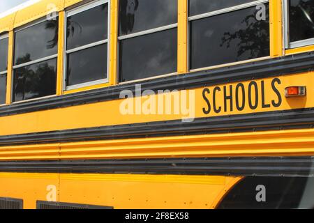 Autobus scolastico giallo da un sistema scolastico pubblico della contea parcheggiato in un parcheggio Foto Stock