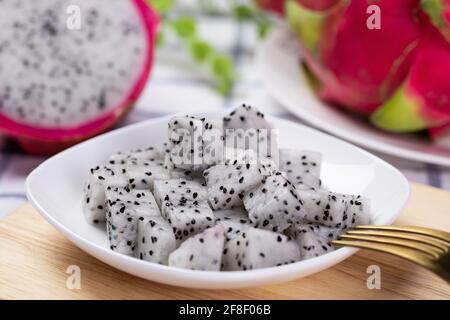 Primo piano di fette di frutta di drago bianche con una forchetta su una piastra Foto Stock