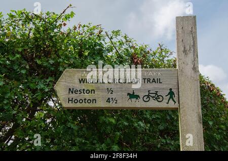 Cartello in legno nel Wirral Country Park che indica un sentiero pedonale, un ponte e un percorso ciclabile sul Wirral Circular Trail verso Neston e Hooton Foto Stock