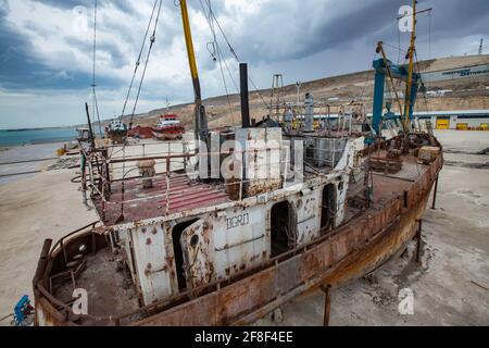 Mangystau, Kazakhstan - 19 maggio 2012: Vecchia nave arrugginita. Baia di Bautino, Mar Caspio. Cantiere di riparazione navale. Grigio cielo nuvoloso tempesta. Foto Stock