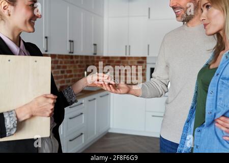 Agente immobiliare dà le chiavi ai clienti Foto Stock