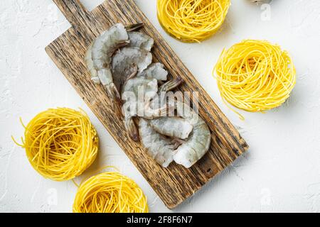 Piatto tradizionale italiano. Pasta con parmigiano di pesto ricotta e frutti di mare alla griglia, su superficie di pietra bianca, vista dall'alto piatto Foto Stock