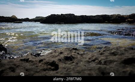 Onde che colpiscono le rocce dell'isola di Ognina, Siracusa, Sicilia, Italia Foto Stock