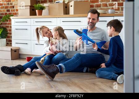 Felice famiglia seduta durante il trasferimento in una nuova casa Foto Stock