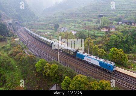 (210414) -- CHANGSHA, 14 aprile 2021 (Xinhua) -- Foto aerea scattata il 11 aprile 2021 mostra il treno 7265 che va alla stazione di Wanyan nella provincia di Hunan della Cina centrale. I treni 7265/7266/7267 iniziarono a funzionare nel 1995, estendendosi per più di 300 chilometri dalla stazione di Huaihua alla stazione di Lixian. I treni passano 37 fermate lungo la strada in 9 ore e 16 minuti. I prezzi dei biglietti variano da 1 yuan a 23.5 yuan (circa 0.15-3.59 dollari USA), che non sono stati aumentati in 26 anni. I treni attraversano le montagne di Wuling. Grazie a loro, gli abitanti del villaggio non solo possono trasportare frutta, verdura Foto Stock