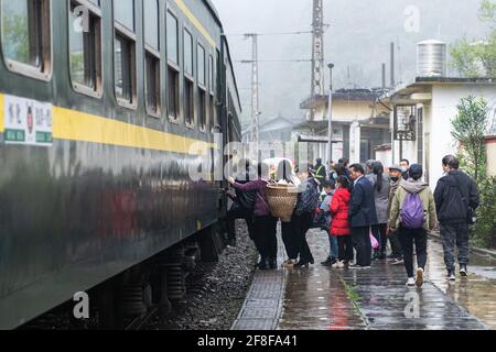 (210414) -- CHANGSHA, 14 aprile 2021 (Xinhua) -- passeggeri a bordo del treno 7266 presso la stazione di Dalongcun nella provincia di Hunan della Cina centrale, 11 aprile 2021. I treni 7265/7266/7267 iniziarono a funzionare nel 1995, estendendosi per più di 300 chilometri dalla stazione di Huaihua alla stazione di Lixian. I treni passano 37 fermate lungo la strada in 9 ore e 16 minuti. I prezzi dei biglietti variano da 1 yuan a 23.5 yuan (circa 0.15-3.59 dollari USA), che non sono stati aumentati in 26 anni. I treni attraversano le montagne di Wuling. Grazie a loro, gli abitanti del villaggio non solo possono trasportare frutta, verdura e altre loca Foto Stock