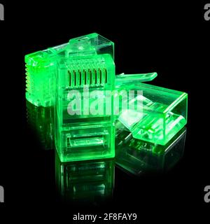 Connettore rj-45. Tre connettori rj45 trasparenti verdi al neon per rete e Internet. Primo piano macro isolata su sfondo nero con riflessione. Foto Stock