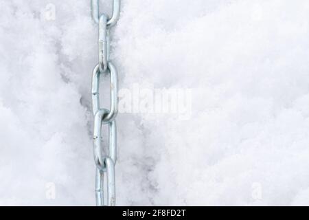 Una catena metallica si trova sulla neve in inverno Foto Stock